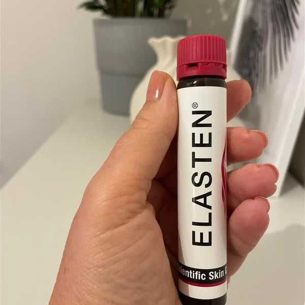 eine Frauenhand hält eine ELASTEN® Trinkampulle in der Hand